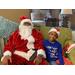 Santa posing with little boy also wearing a Santa hat