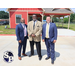 Three men standing together outside.