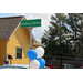 Side view of a house. A street sign with balloons attached.