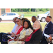 Some people sitting and listening at the ribbon cutting.